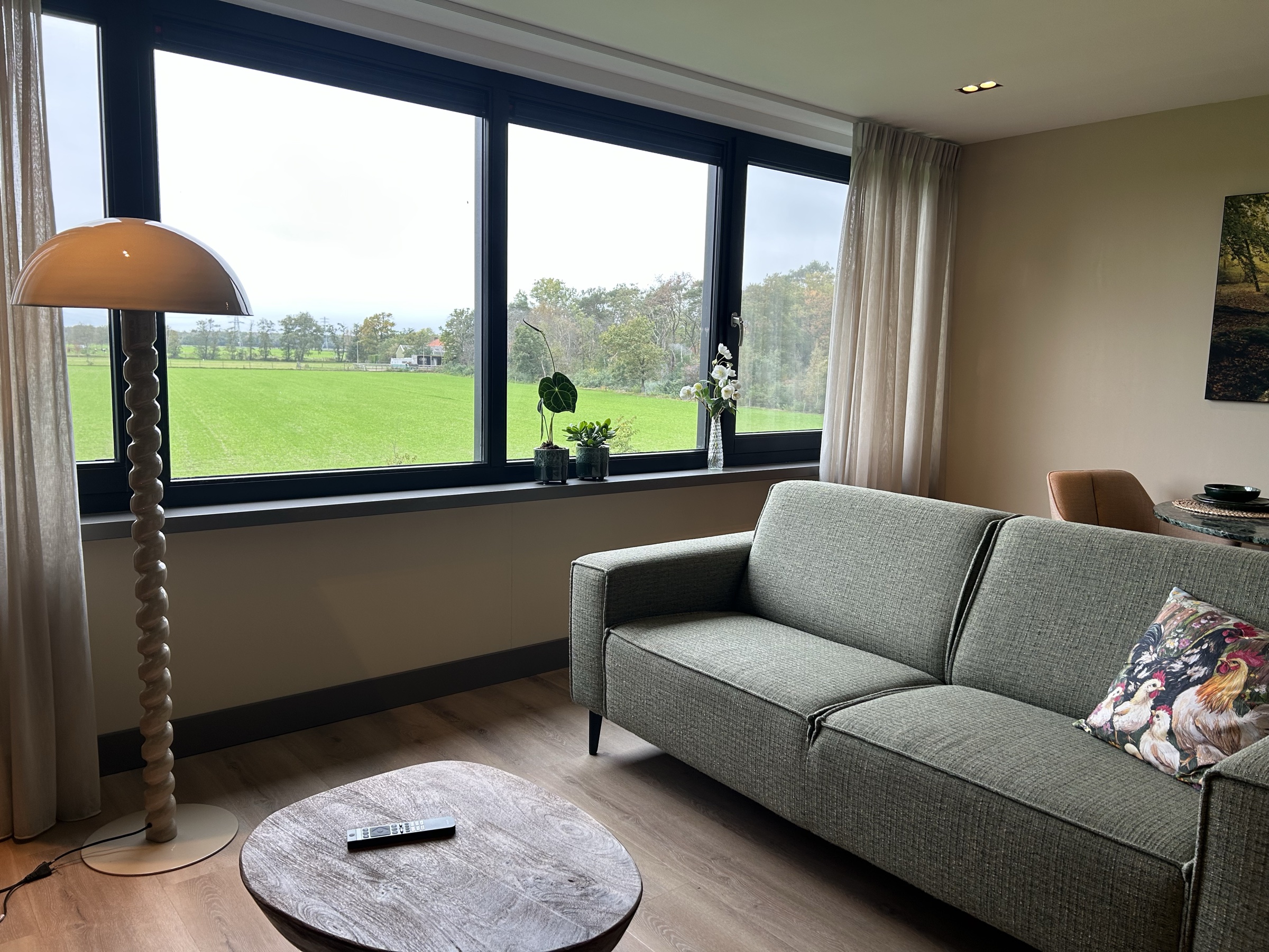 Lichte zithoek van Studio Veluwe met uitzicht over het groene landschap